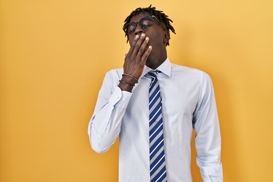 African Man With Dreadlocks Standing Over Yellow Background Bored Yawning Tired Covering Mouth With Hand. Restless And Sleepiness.