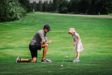 Golf Lessons. Golf instructor giving game lesson to a young girl