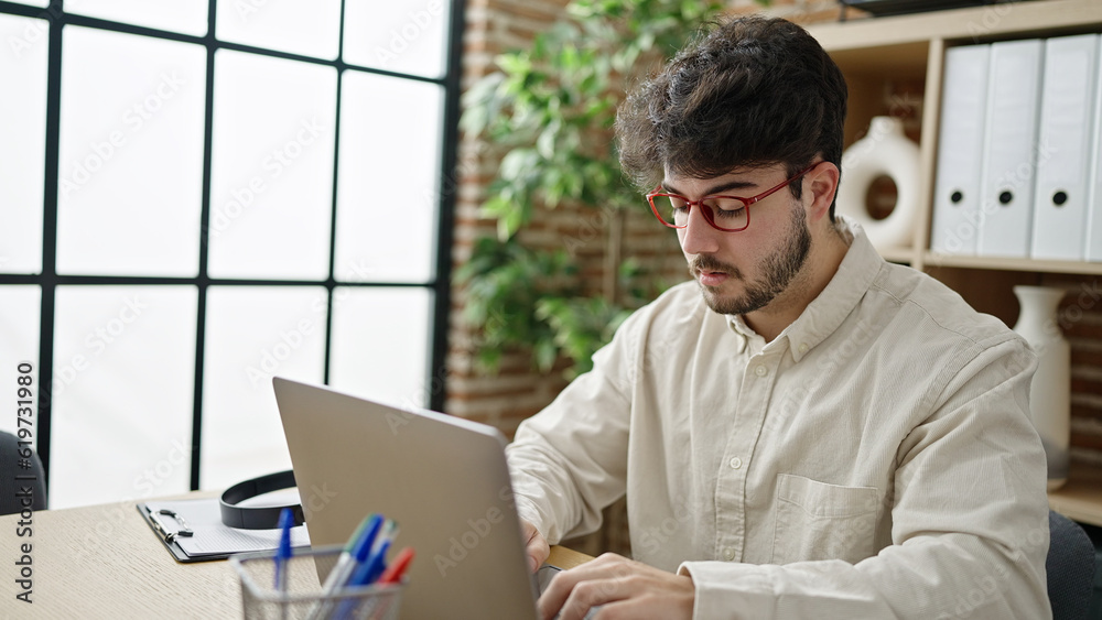 Sticker young hispanic man business worker using laptop working at office