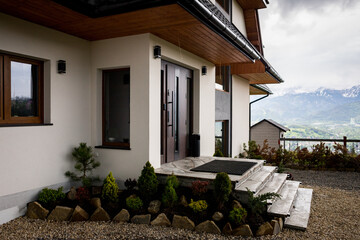 Panorama of a mountain range and a standing lonely house among the mountains. Cloudy weather in the mountains.