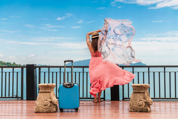 Happy joyful traveler woman in dress waving fabric on wood pier at sea shore, Attractive stylish glamour tourist girl travel Thailand summer holiday vacation trips, Tourism beautiful destinations Asia