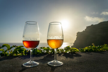 Two different glasses of Madeira wines at sunset, wine tasting, Madeira island, Portugal