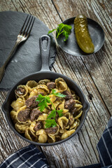 Italian pasta shells with beef sauce in cast iron pan.