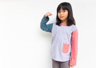 A cute confident girl looking at camera raised hand showing her bicep muscle