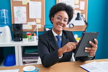 African american woman business worker smiling confident using touchpad at office