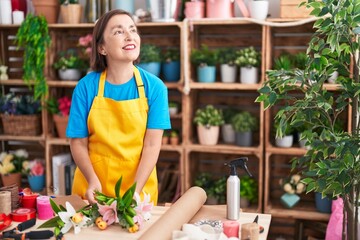Middle age woman florist make bouquet of flowers at flower shop