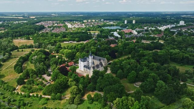 Drone shot of Wolfsburg Castle ( Schloss Wolfsburg ) . The Wolfsburg is a medieval lowland and water castle in North Germany .
