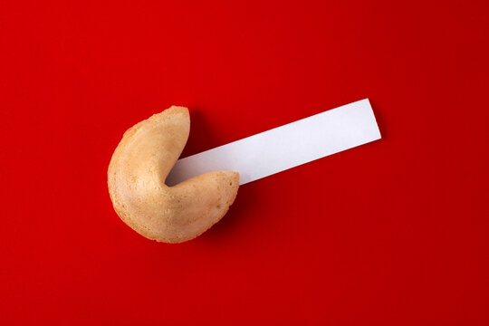 Traditional fortune cookie with empty white note on red background