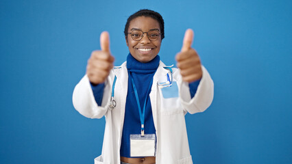 African american woman doctor doing thumbs up over isolated blue background