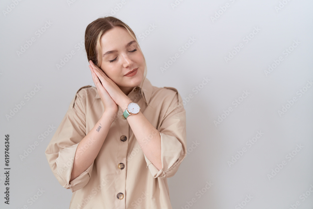 Sticker Young caucasian woman wearing casual shirt sleeping tired dreaming and posing with hands together while smiling with closed eyes.