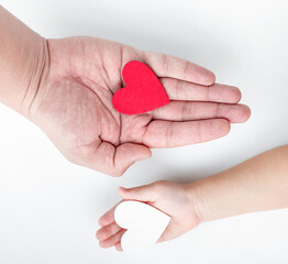 Obraz premium Hand of an adult and a child's hand holding a heart