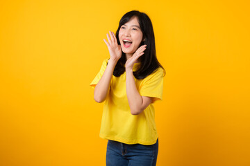 Portrait of a Young Asian Woman with Shout Hands Gesture Isolated on Yellow Studio Background