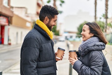 Man and woman couple smiling confident drinking coffee at street
