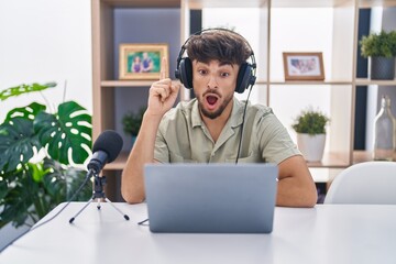 Arab man with beard working at the radio pointing finger up with successful idea. exited and happy. number one.