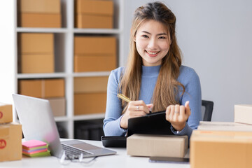 Fototapeta na wymiar Portrait of asian young freelancer small business startup, SME owner, asian female entrepreneur work and check orders online at home. online SME business idea.