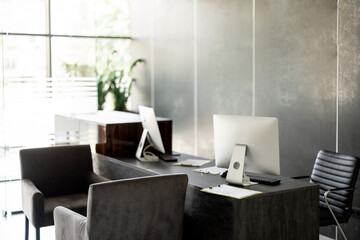 Reception with computers of a modern clinic in gray tones with no people