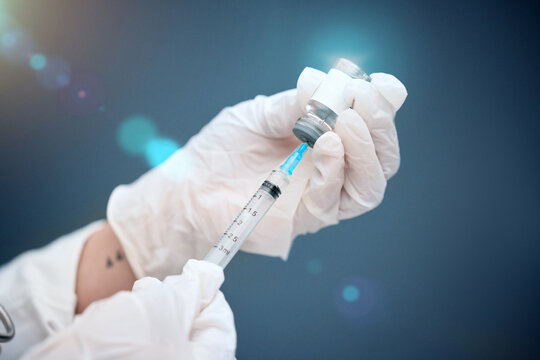 Closeup, Hands And Vial With Medicine, Injection And Needle With A Doctor On A Blue Studio Background. Zoom, Gloves And Medical Professional With Healthcare, Needle And Vaccine With Pharma Research