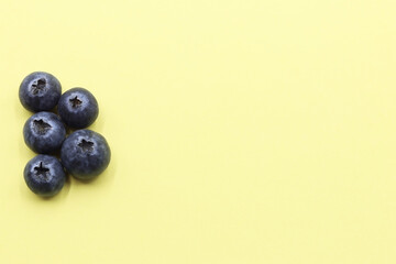 Some blueberries on a yellow background. Space for text
