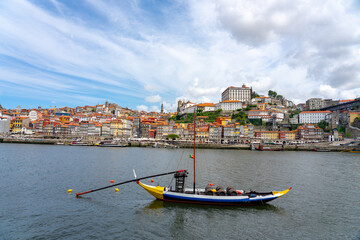 boat with wine barrels with Beautiful colorful building facede background in Porto Portugal next to Duero river in Ribeira - obrazy, fototapety, plakaty
