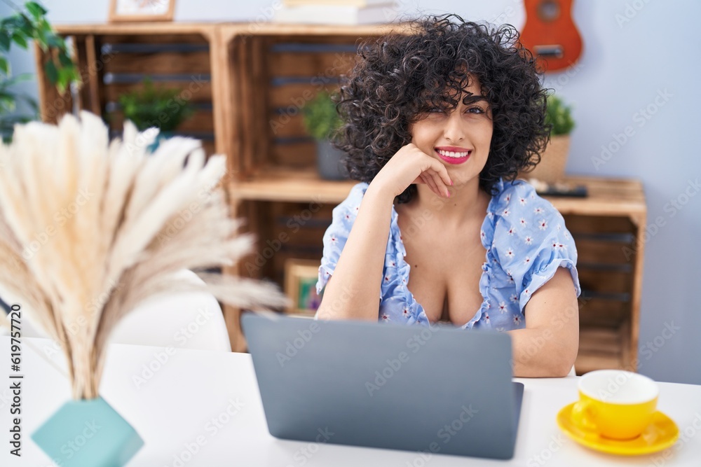 Wall mural young middle east woman using laptop and drinking coffee at home