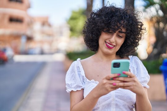 Young middle east woman smiling confident using smartphone at park