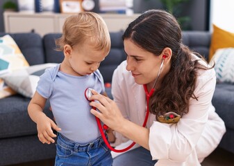 Mother and son doctor examining child at home
