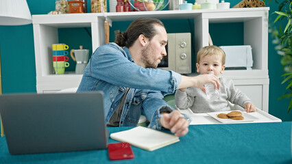 Father and son working and taking care child at dinning room