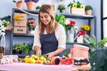 Young woman florist make bouquet of flowers at florist