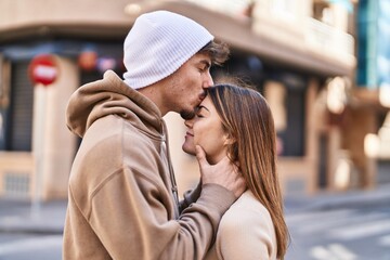 Mand and woman couple standing together and kissing at street