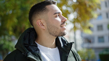 Young hispanic man smiling confident standing at park