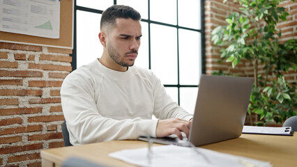 Young hispanic man business worker using laptop working at office