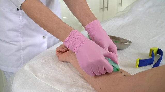 3 step of the procedure. the hands of a nurse or beautician in pink gloves finishes the process taking a blood sample from a vein on the patient's arm. the patient bends his arm and leaves.