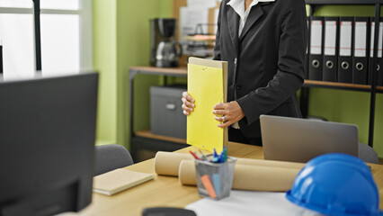 Young beautiful hispanic woman business worker holding documents at office