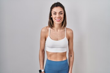 Hispanic woman wearing sportswear over isolated background with a happy and cool smile on face. lucky person.