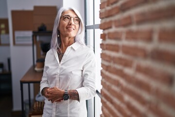 Middle age grey-haired woman business worker smiling confident standing at office