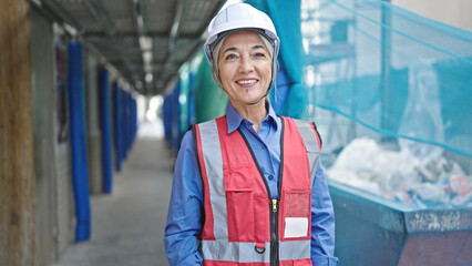 Middle age grey-haired woman builder smiling confident standing at street