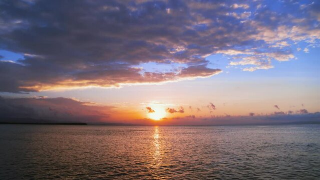 Calm tropical sea with sunset sky and orange sun through the clouds. Ocean and sky for meditation. Calm seascape. Horizon over water. Breathtaking sunset over the sea.