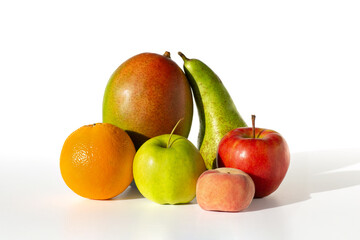 Fototapeta na wymiar fresh fruit group - apple green and red, pear, mango and orange, lie on a white table, isolated
