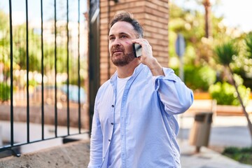 Young caucasian man talking on the smartphone with serious expression at street