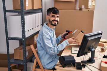 Young hispanic man ecommerce business worker scanning package at office