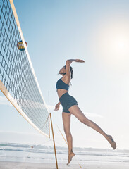 Woman, jump and volleyball player on beach by net in serious sports match, game or competition....