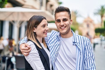 Man and woman couple smiling confident hugging each other at street