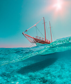 Foto di paesaggio con domeport (met&agrave; sott'acqua e met&agrave; sopra), nella parte bassa i meravigliosi fondali dell'arcipelago di La Maddalena, nella parte alta un veliero che solca il mare color smeraldo.