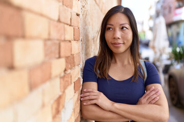 Young asian woman standing with arms crossed gesture at street