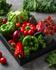 assorted red and green vegetables tomatoes, bell peppers, kale avocado