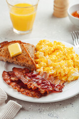 traditional scrambled egg breakfast with bacon and toast
