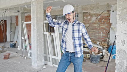 Middle age man builder smiling confident dancing at construction site