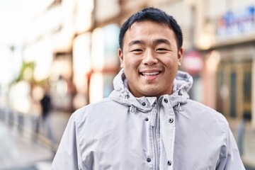 Young chinese man smiling confident standing at street