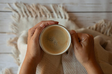 taza de café con espuma en manos de una mujer, vista cenital