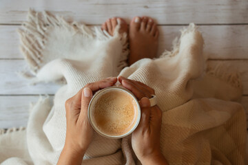 taza de café con espuma en manos de una mujer, vista cenital